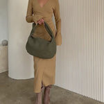 Video of a model wearing a suede recycled vegan leather shoulder bag. 