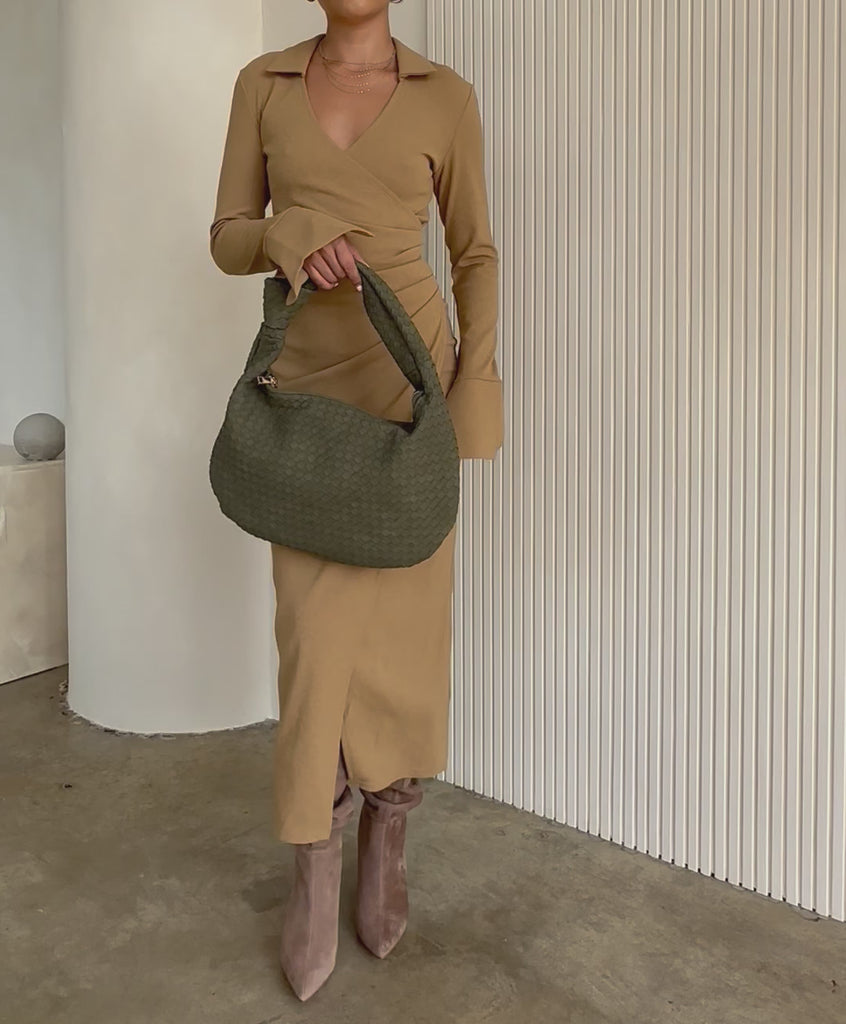 Video of a model wearing a suede recycled vegan leather shoulder bag. 