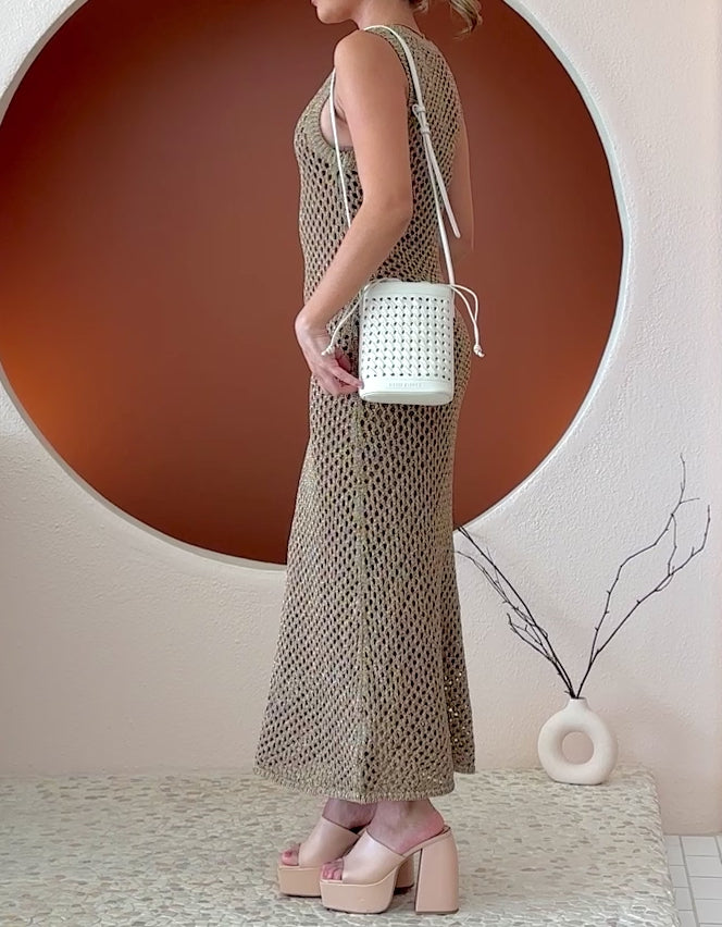 Video of a model wearing a small woven vegan leather crossbody pouch with a drawstring closure.