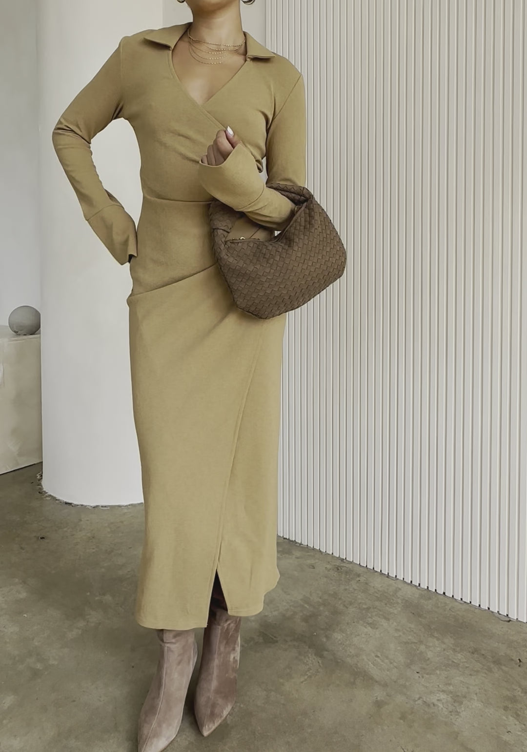 Video fo a model holding a suede recycled vegan leather top handle bag with a knot.