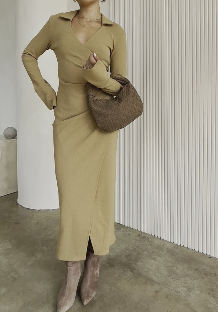 Video fo a model holding a suede recycled vegan leather top handle bag with a knot.