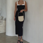 Video of a model holding a ivory crossbody handbag with silver handle.