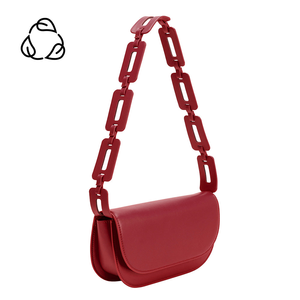 A small red vegan leather shoulder bag with a scalloped strap.