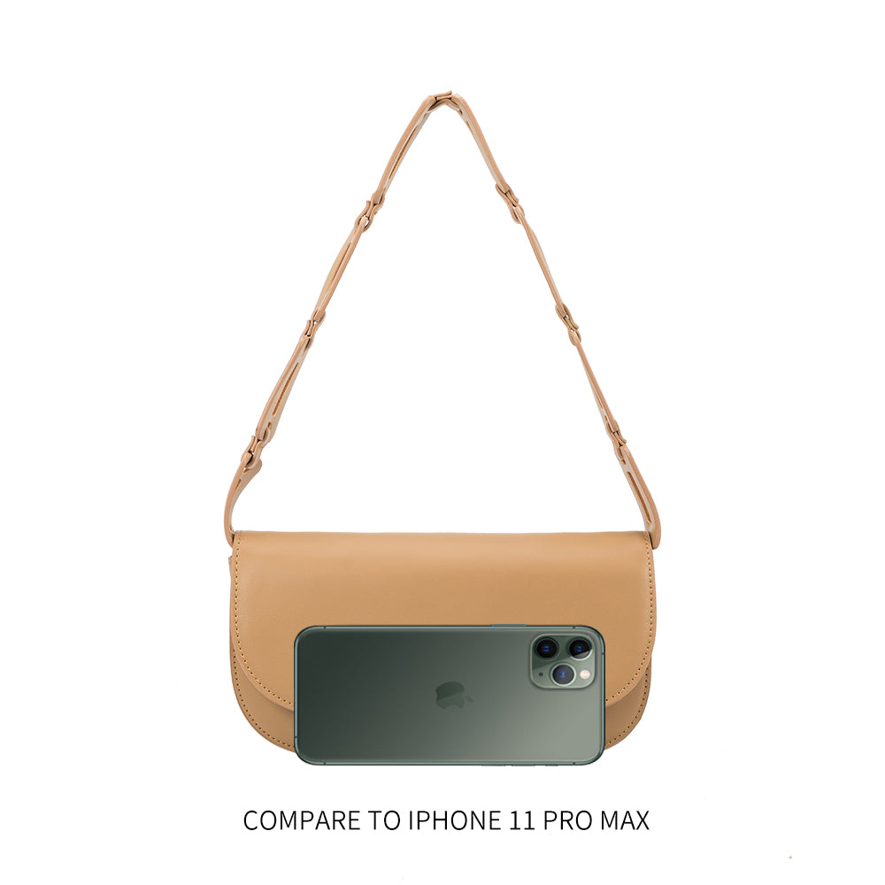 An iphone 11 size comparison image of a small vegan leather shoulder bag with a scalloped strap