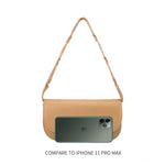An iphone 11 size comparison image of a small vegan leather shoulder bag with a scalloped strap.