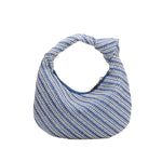 A small blue straw woven top handle bag with a knot handle
