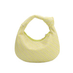 a small yellow straw woven top handle bag with a knot handle