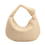A large natural straw woven shoulder bag with a knot handle