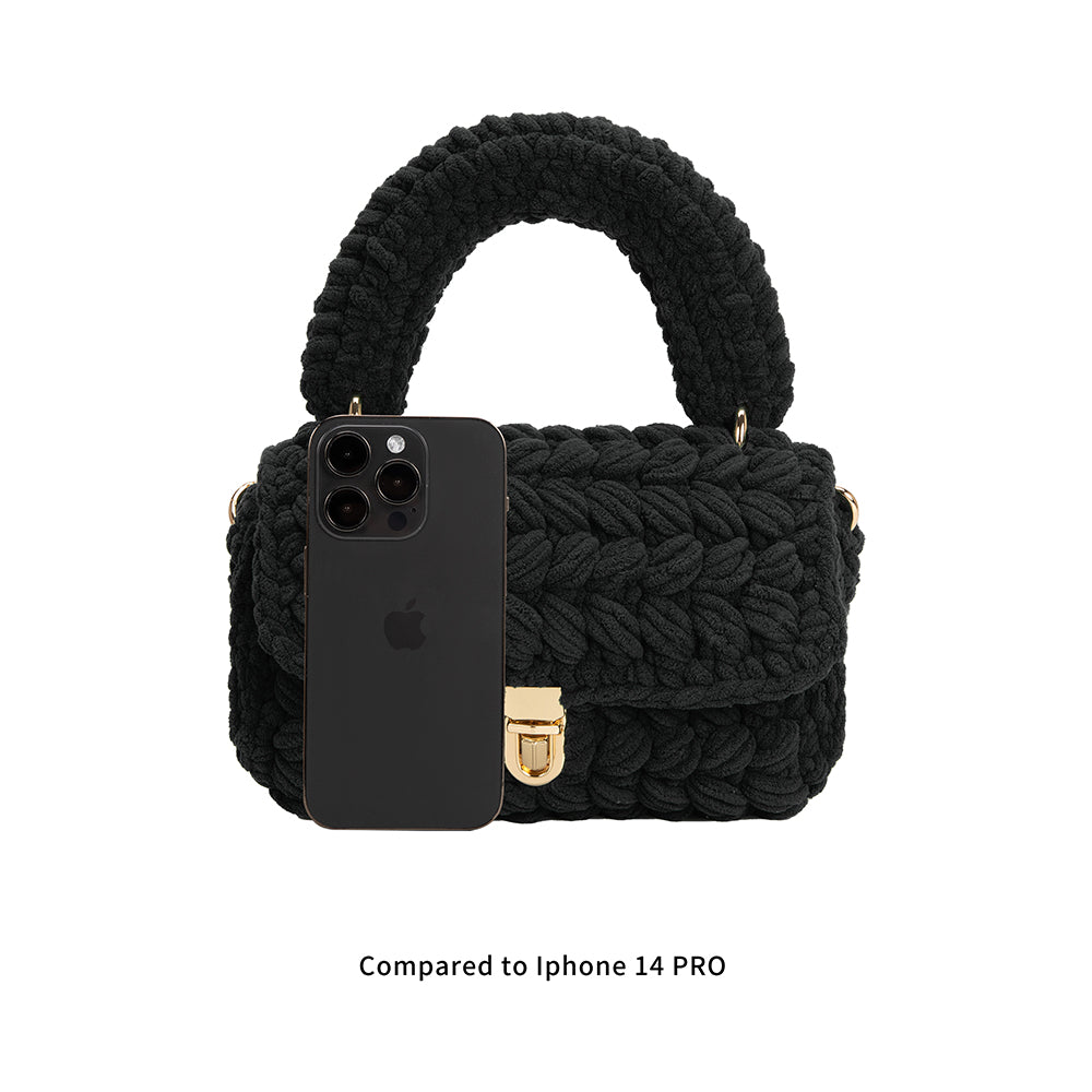 A black knitted crossbody handbag with Iphone 14 for size comparison.