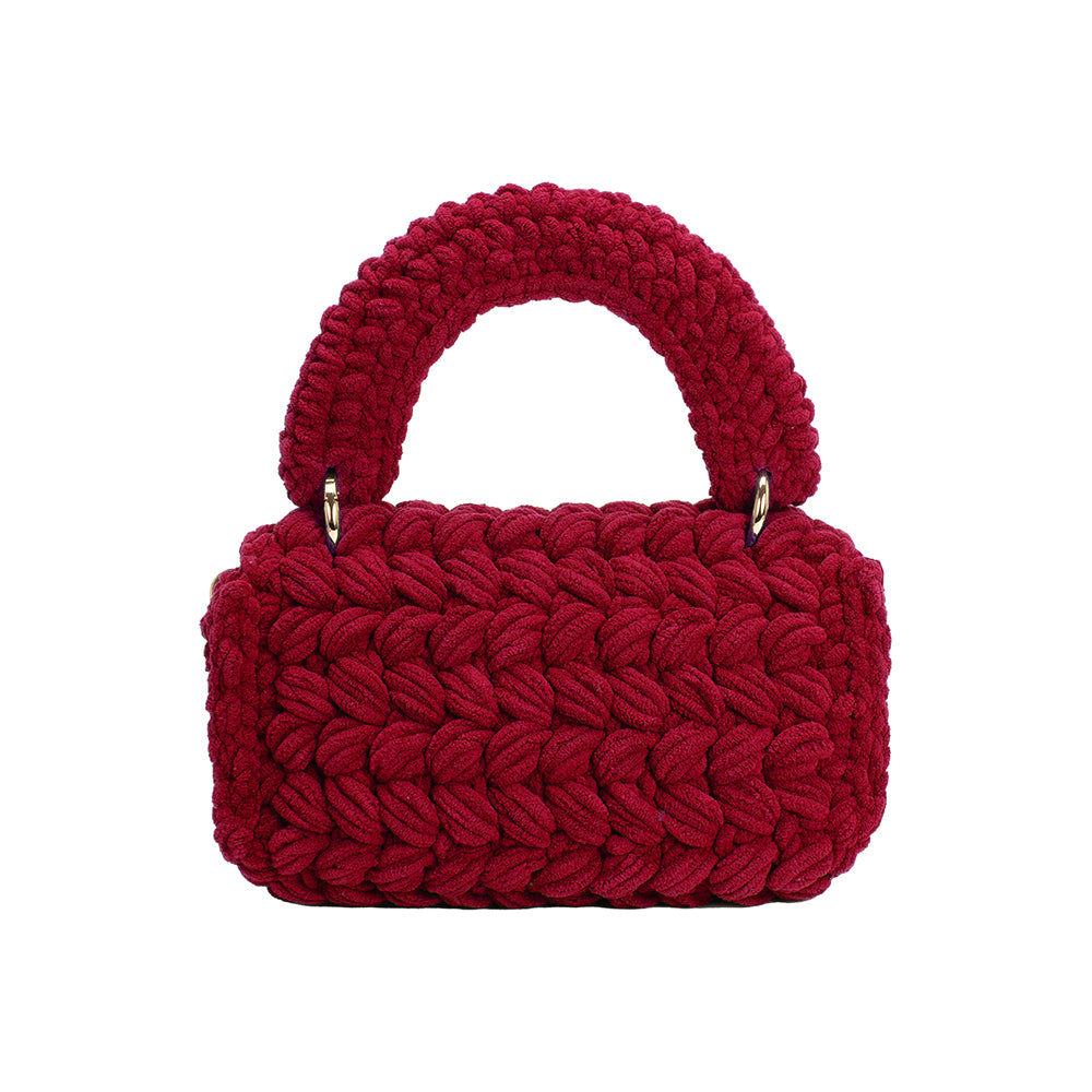 A plum knitted crossbody handbag with gold clasps. 
