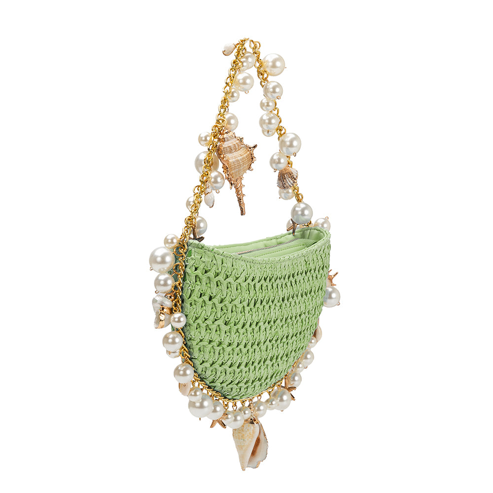 A small lime crochet straw top handle bag with seashell details along the handle.