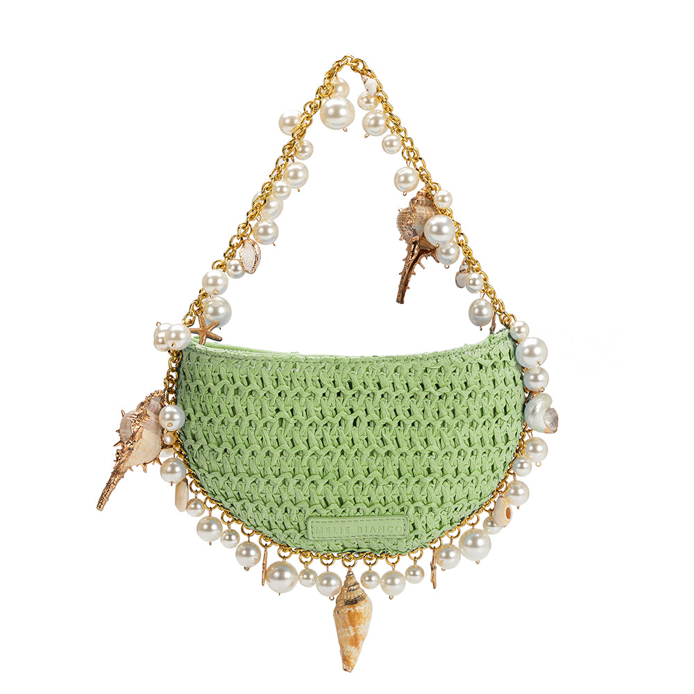 a small lime crochet straw top handle bag with seashell details along the handle.