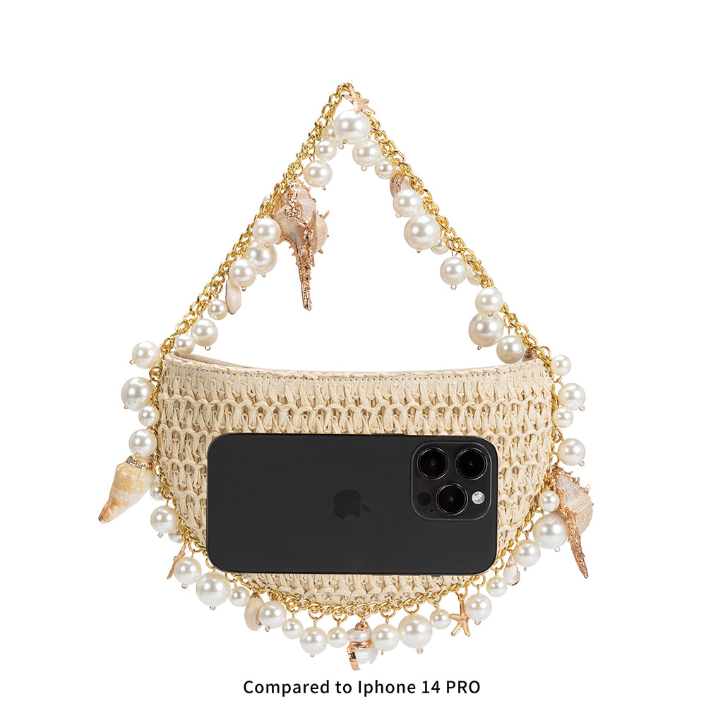 An iphone 14 size comparison image of a small crochet straw top handle bag with seashell details along the handle.