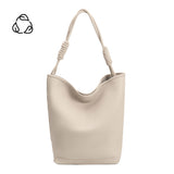 A large ivory vegan leather tote bag with a knotted handle.