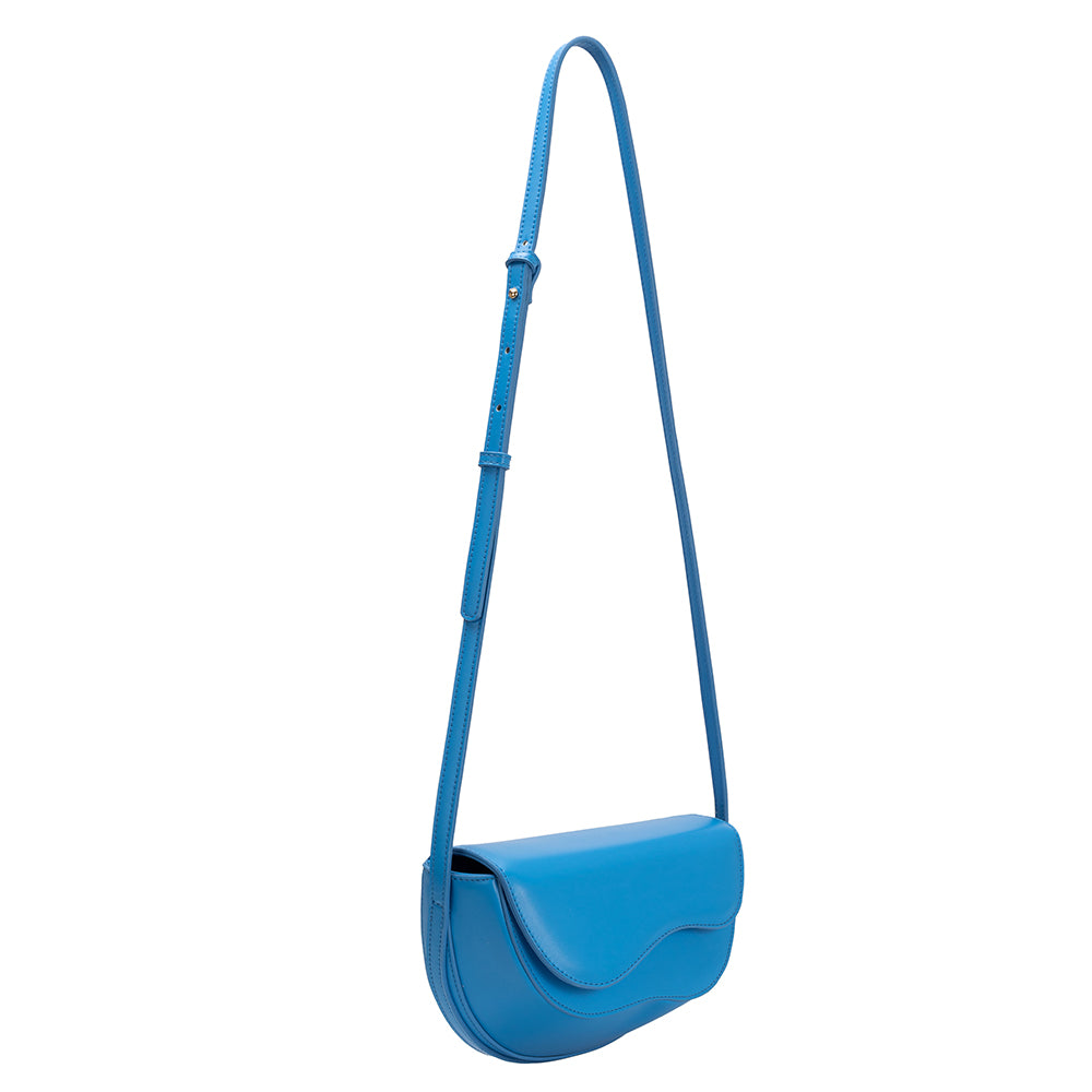 A small blue vegan leather crossbody bag with a wavy front flap closure.