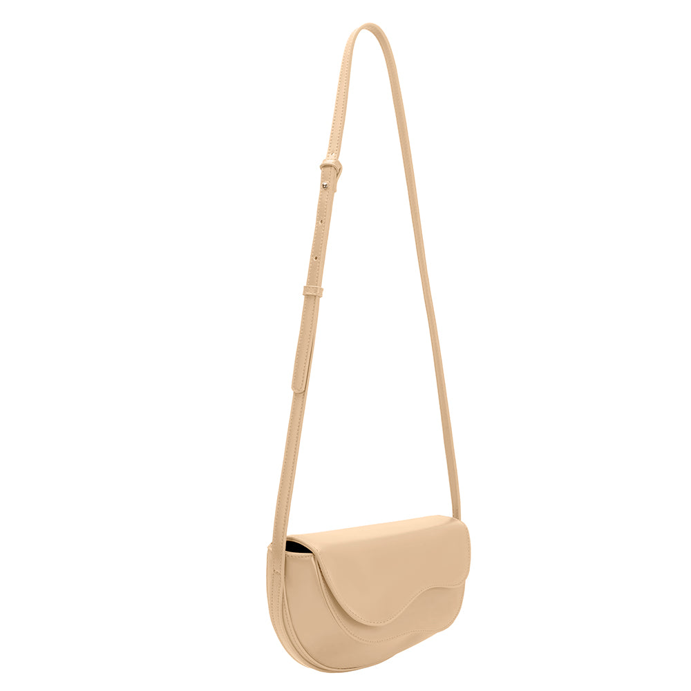 A small nude vegan leather crossbody bag with a wavy front flap closure.