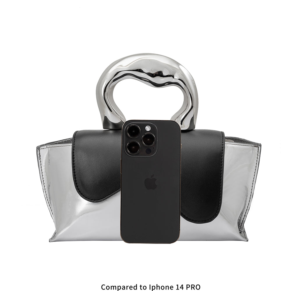 an iphone 14 size comparison image of a small metallic vegan leather top handle bag.