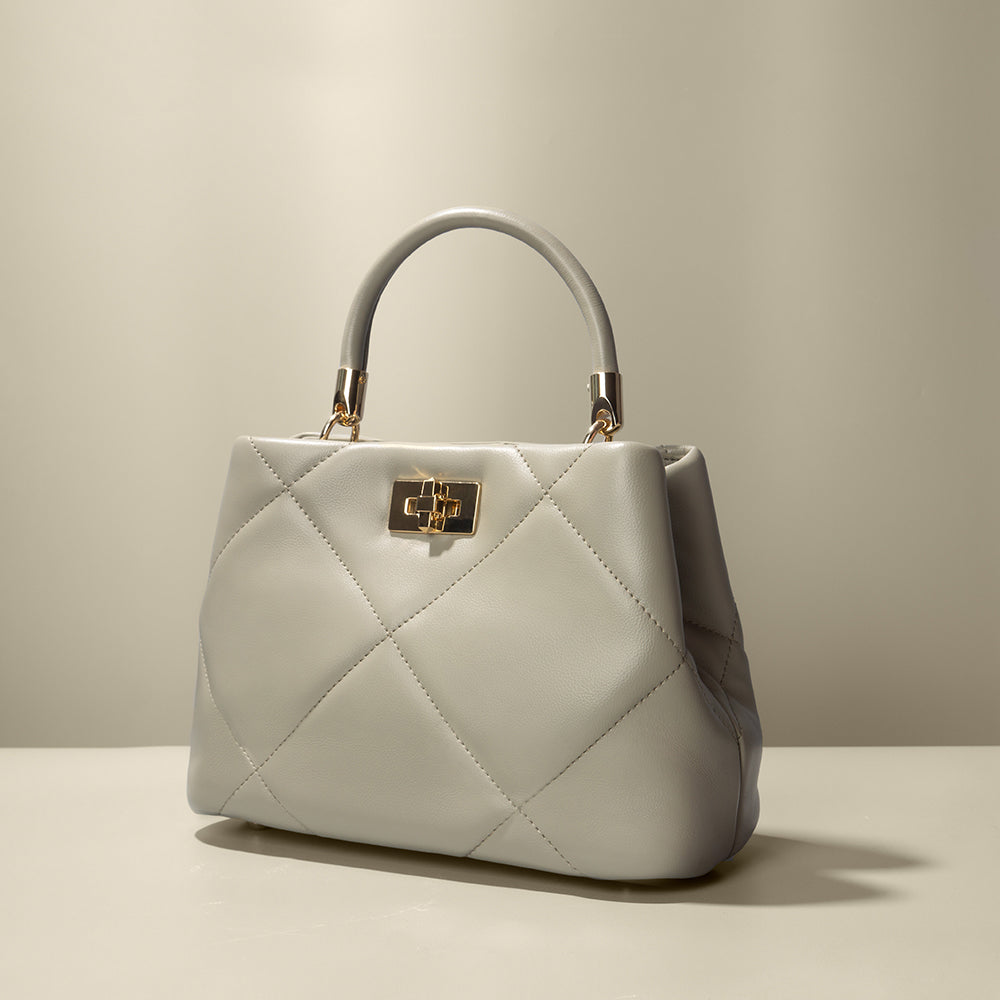 A mushroom crossbody handbag with gold clasps.