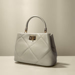 A mushroom crossbody handbag with gold clasps.
