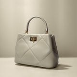 A mushroom crossbody handbag with gold clasps.