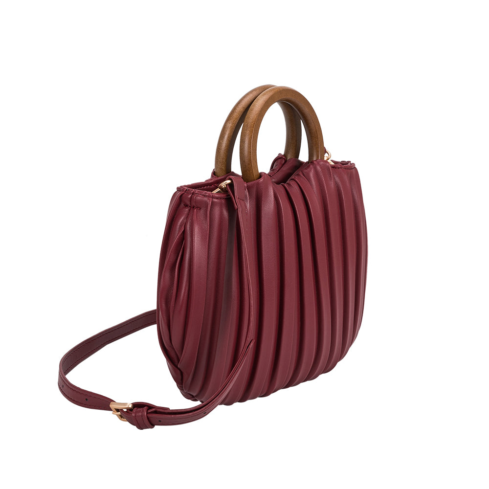 A small burgundy vegan leather crossbody bag with pleated detail and a wooden handle.