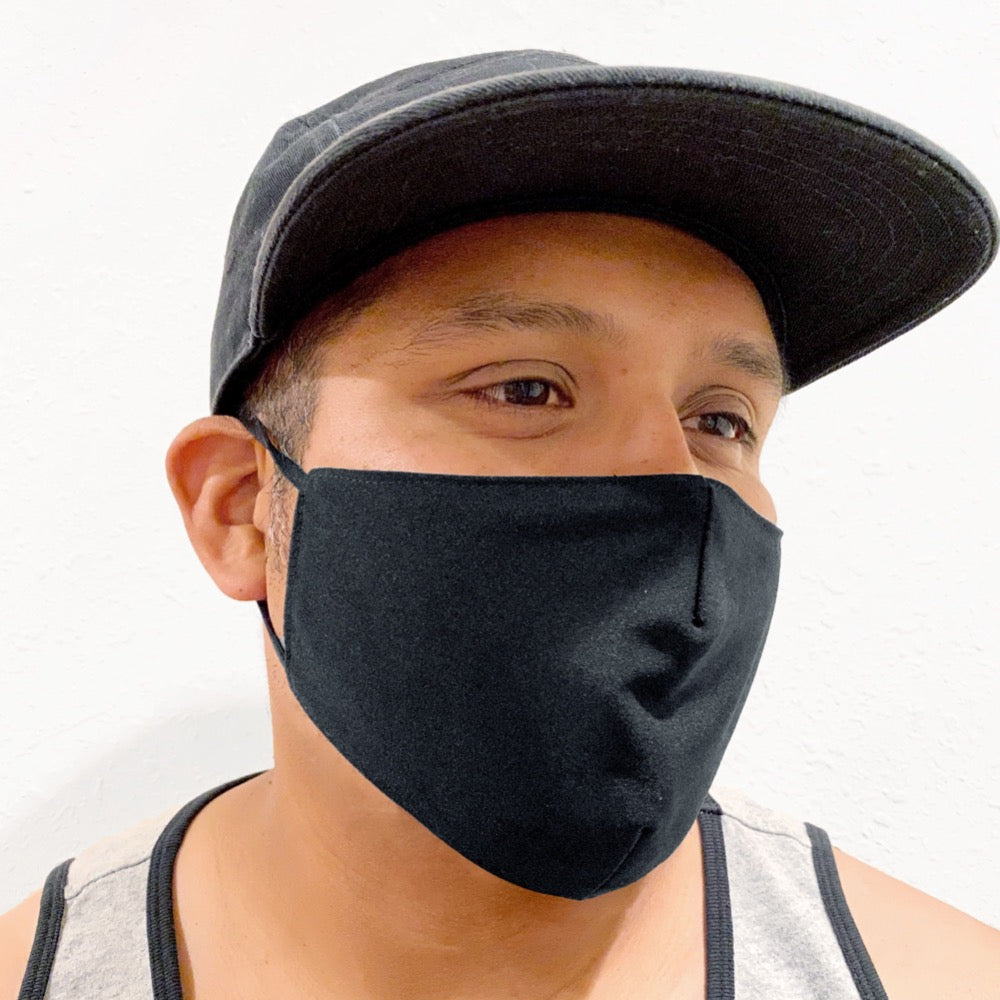 A model wearing a solid black face mask with strings on each side. 