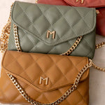 A still image of three small quilted vegan leather shoulder bags laying against each other.
