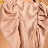 A detail image for a tan puff sleeve knit bodysuit on a hanger.