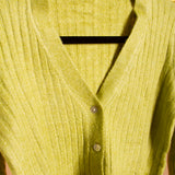A still detail image of a green rib knit cardigan on a hanger. 