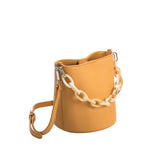 A small mango recycled vegan leather crossbody bag with an acrylic chain. 