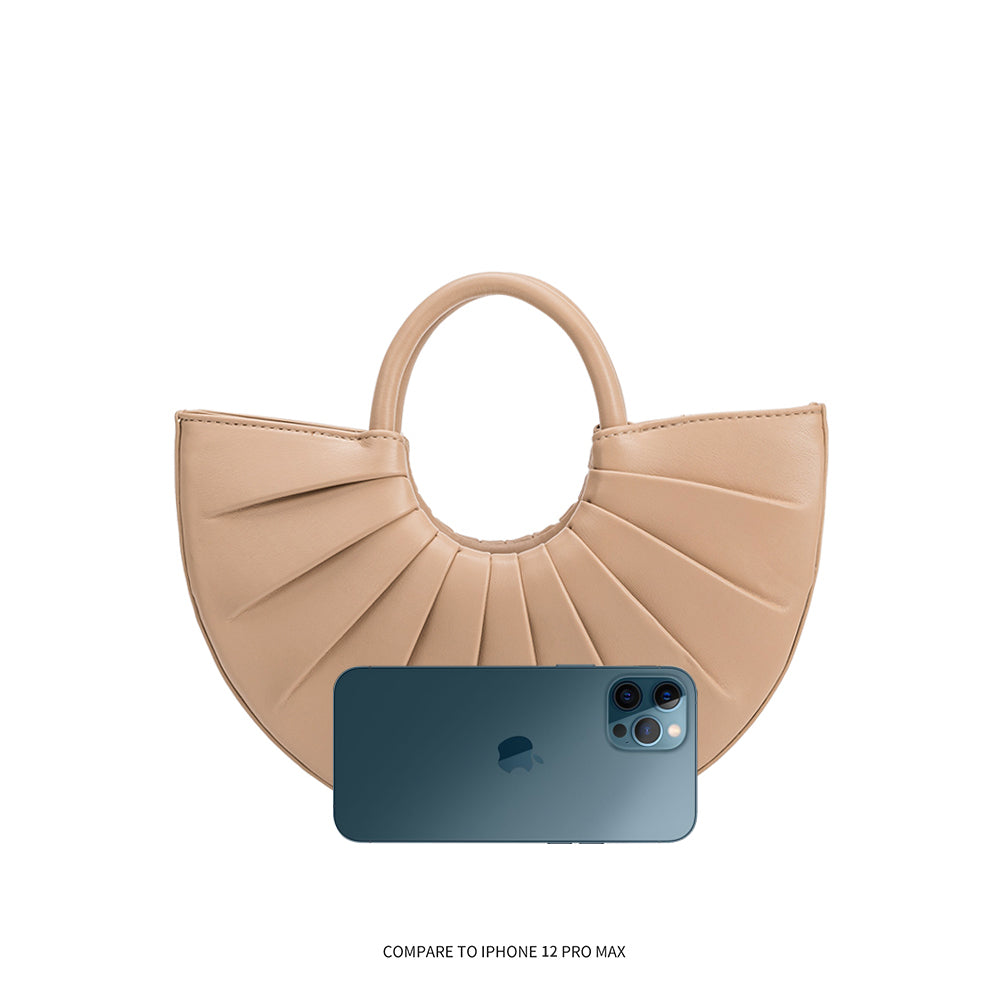 An iphone 12 pro size comparison image for a small semi circle vegan leather top handle bag with pleated detail.