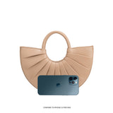 An iphone 12 pro size comparison image for a small semi circle vegan leather top handle bag with pleated detail.