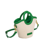 A small green canvas and vegan leather crossbody bag with a circle handle.