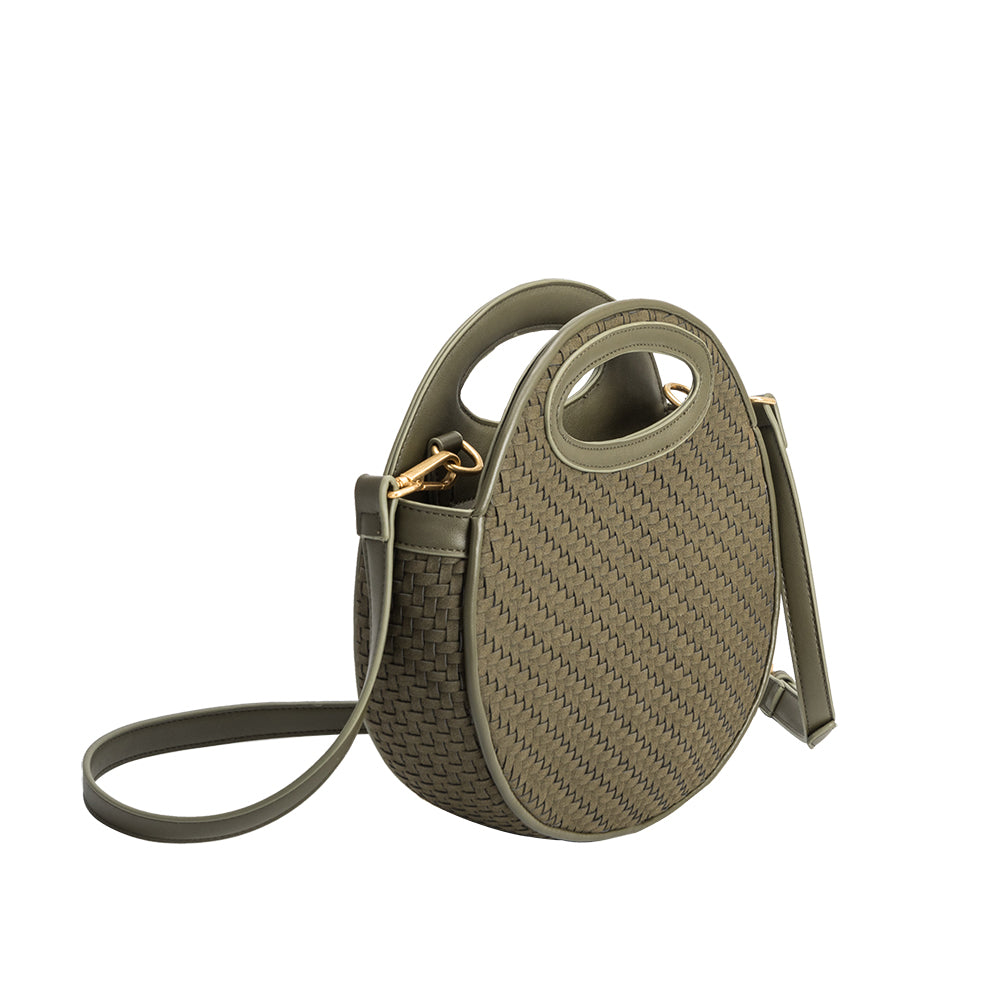 An olive circle vegan leather crossbody bag with woven pattern.