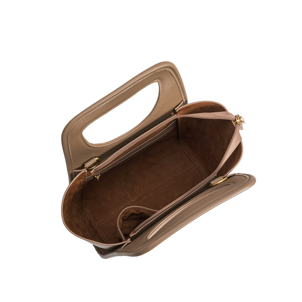 A taupe square shaped recycled vegan leather top handle bag. 
