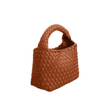 A small saddle hand woven vegan leather top handle bag.