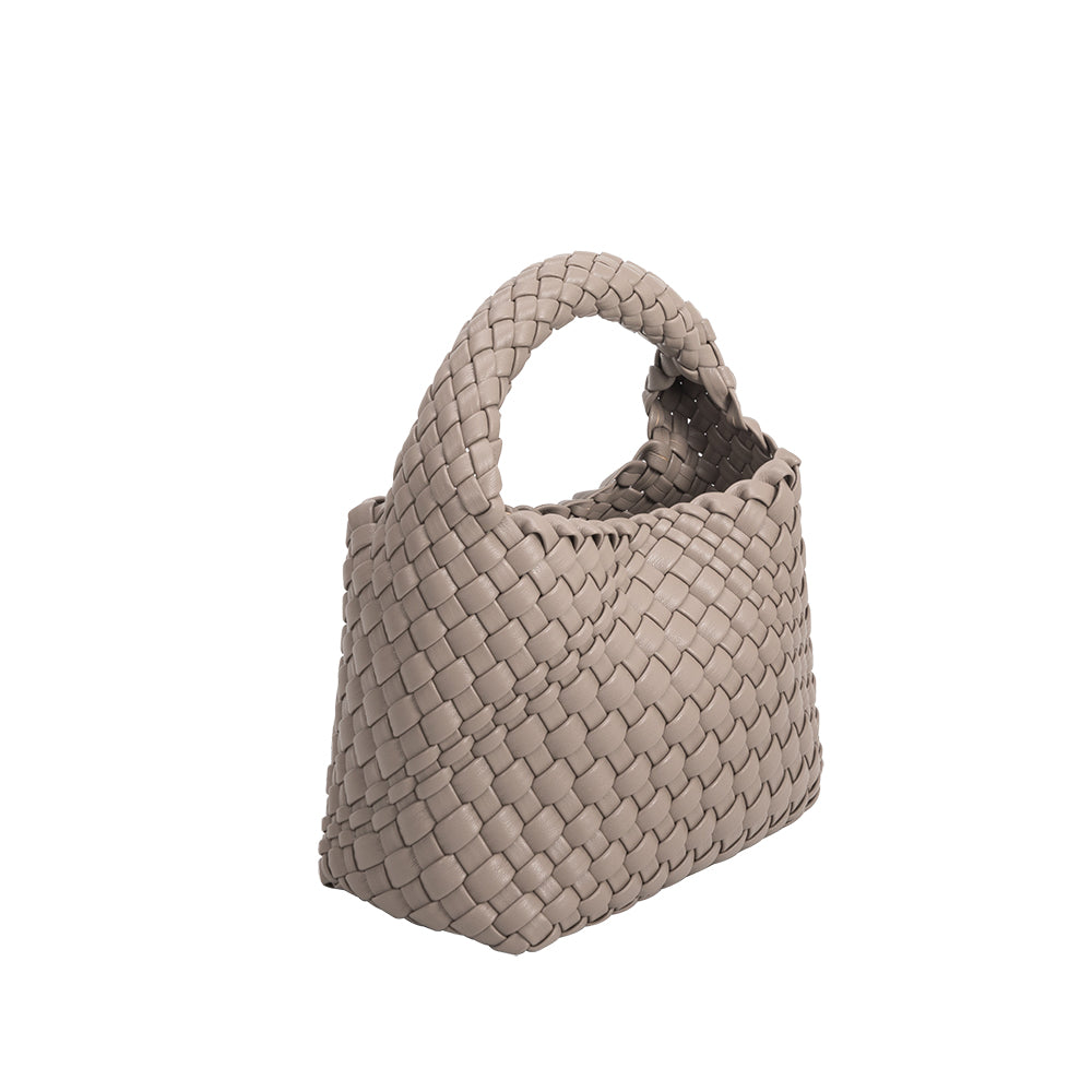 A small taupe hand woven vegan leather top handle bag.