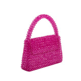 A small fuchsia crystal beaded top handle bag with a flap closure. 