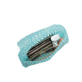 An inside view image for a crystal beaded top handle bag with a wallet, phone and makeup.