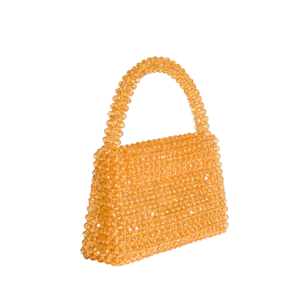 A small citrine crystal beaded top handle bag with a flap closure. 