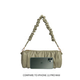 An iphone 11 pro size comparison image for a medium cylindrical-shaped shoulder bag with a ruched body and strap. 