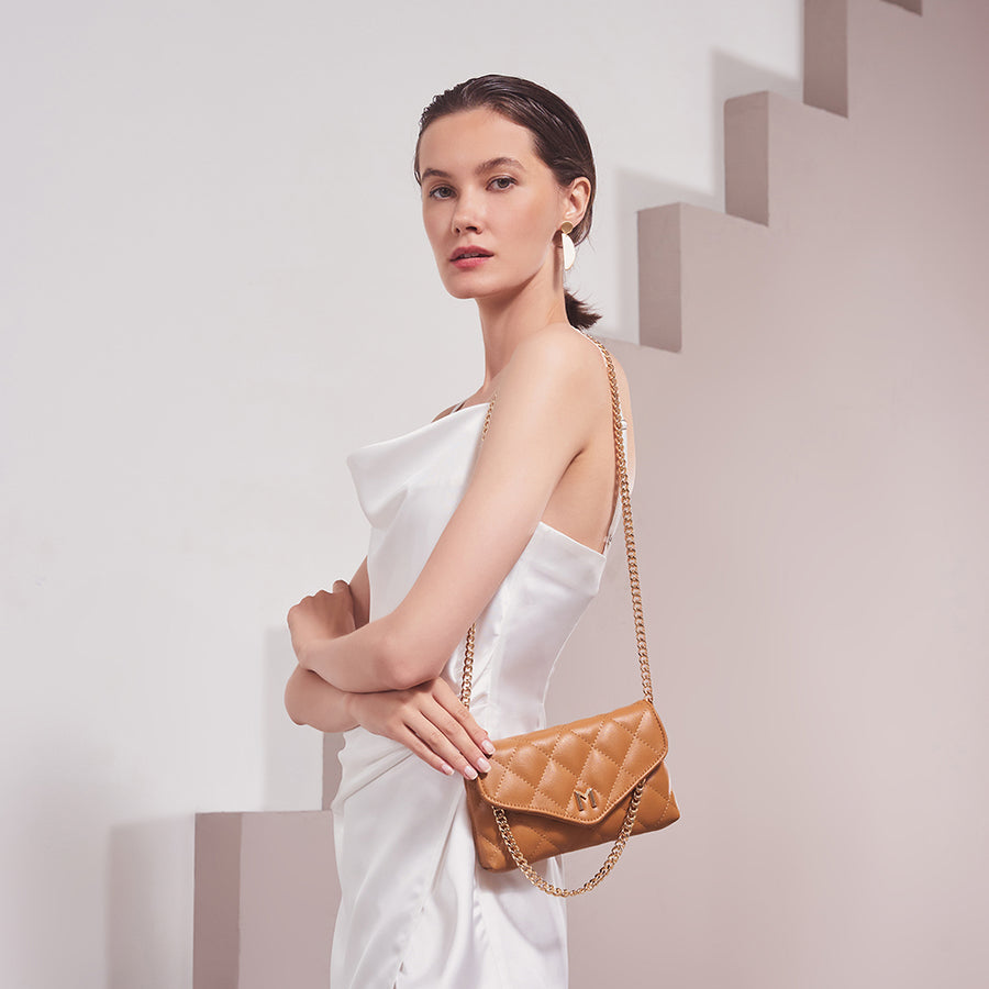 Model Wearing Melie Bianco Luxury Vegan Leather Gigi Clutch Bag in Camel with gold chain