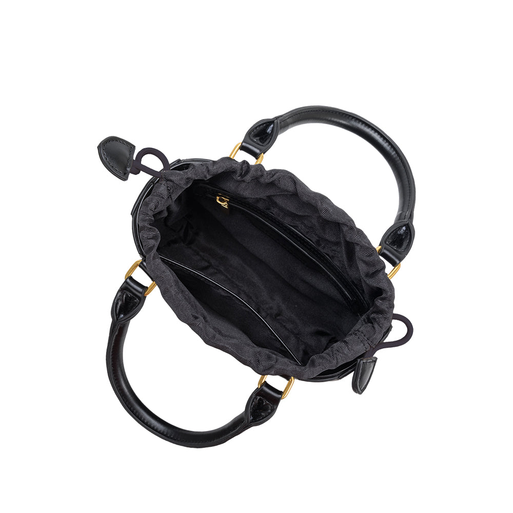 A black  accordion-paneled recycled vegan leather crossbody handbag.