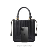 A Iphone 14 pro size comparison image for a black  accordion-paneled recycled vegan leather crossbody handbag.