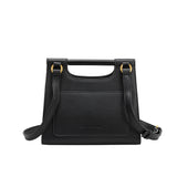 A small black square structured vegan leather crossbody bag with a wooden handle. 