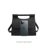 An iphone 14 size comparison image for a small square vegan leather crossbody bag with a wooden handle. 