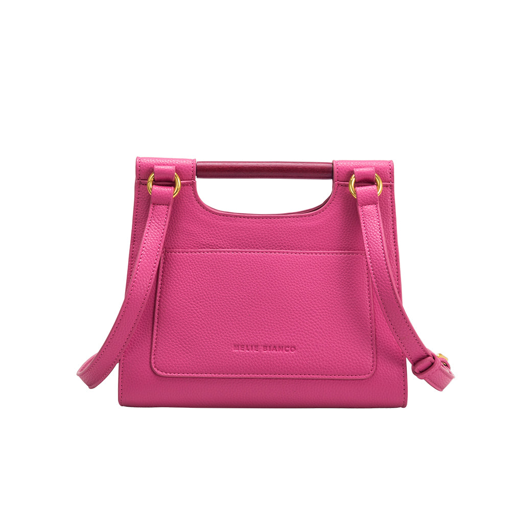 A small fuchsia vegan leather crossbody bag with a wooden handle. 